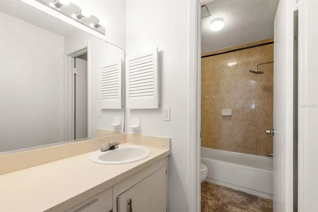 a view of a big room with wooden floor and a kitchen