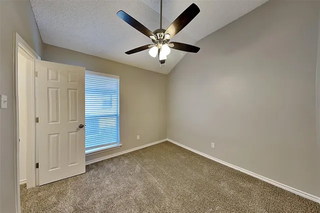 an empty room with closet and ceiling fan