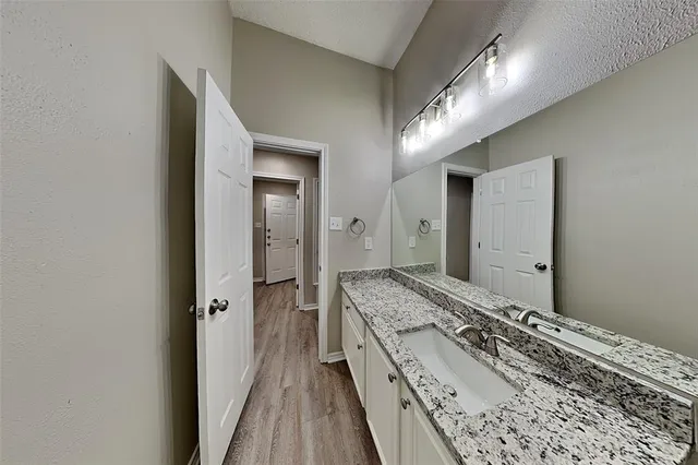 a spacious bathroom with a granite countertop sink and a mirror