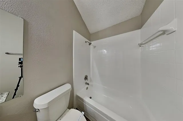 a white toilet sitting next to a bath tub shower