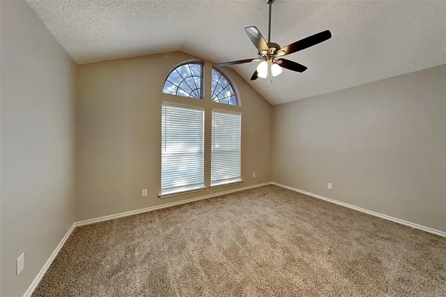 an empty room with a window and a ceiling fan
