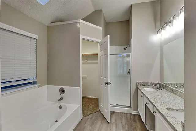 a bathroom with a granite countertop tub sink and mirror