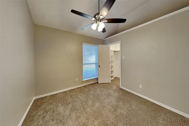 an empty room with fan and a ceiling fan
