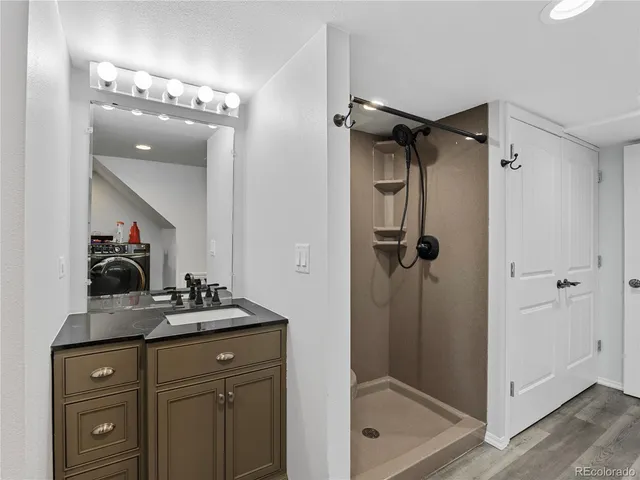 a bathroom with a sink vanity and shower