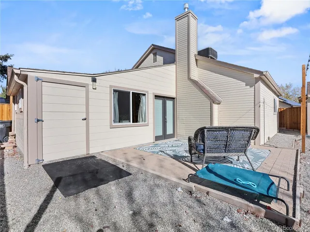 a backyard of a house with table and chairs