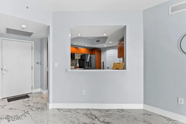 a view of a hallway with wooden floor and a living room