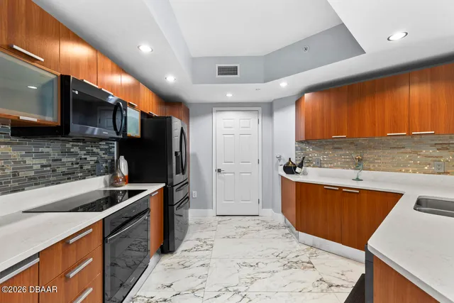 a kitchen with stainless steel appliances granite countertop a sink stove and refrigerator