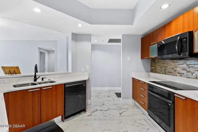 a kitchen with stainless steel appliances granite countertop a sink stove and microwave