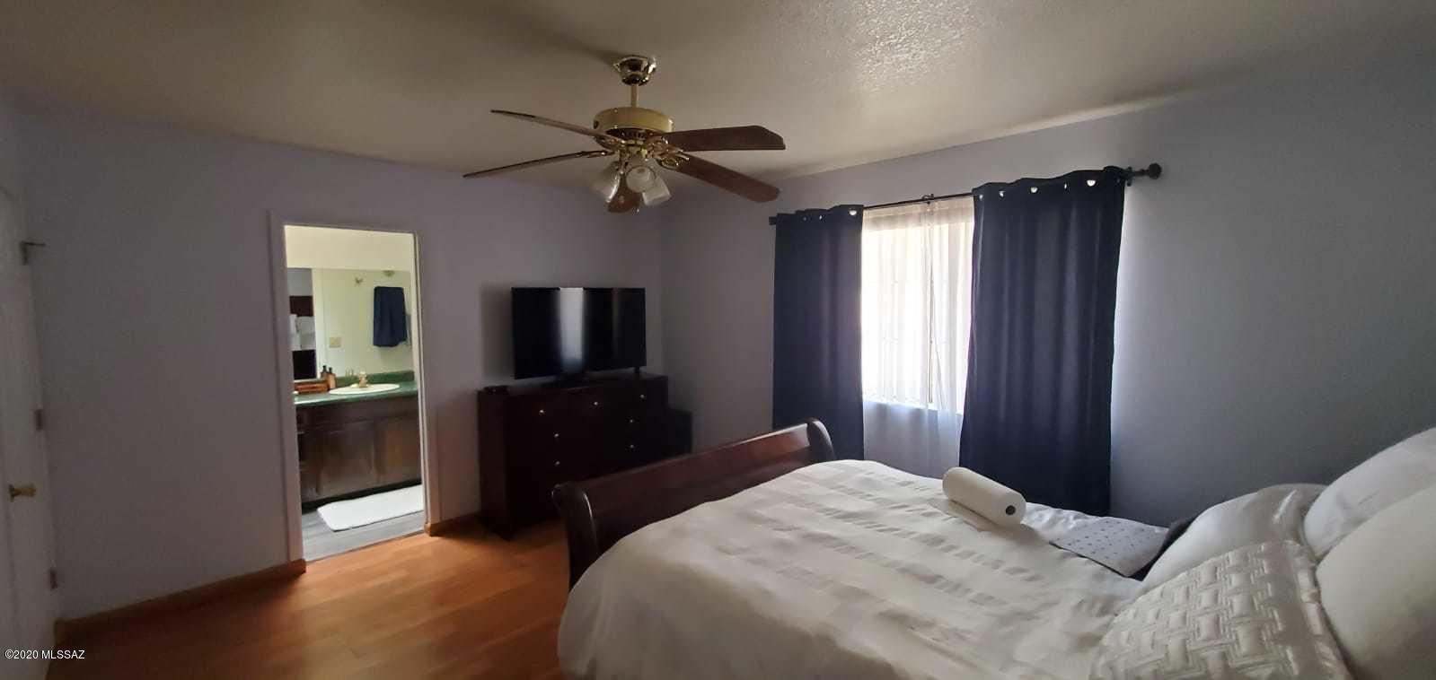 173 Nabo Court Rio Rico, AZ 85648 - Photo 19 of 26 a bedroom with a bed and a chandelier