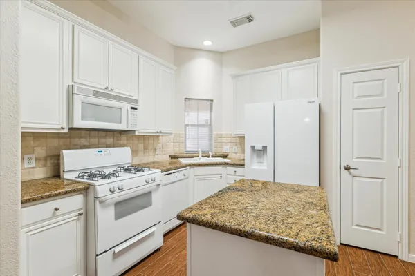 a kitchen with white cabinets and white appliances