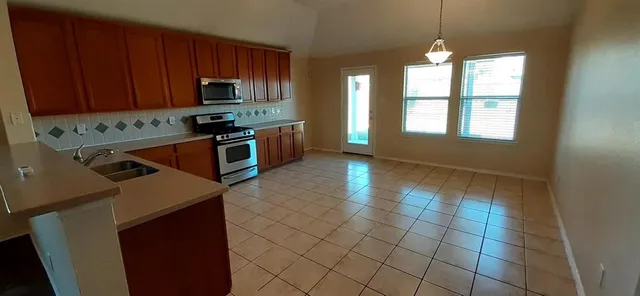 a kitchen with stainless steel appliances a stove a sink and a microwave