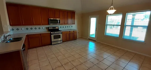 a kitchen with stainless steel appliances granite countertop a stove a sink and a microwave