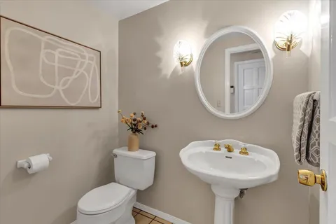 a bathroom with a toilet sink and mirror