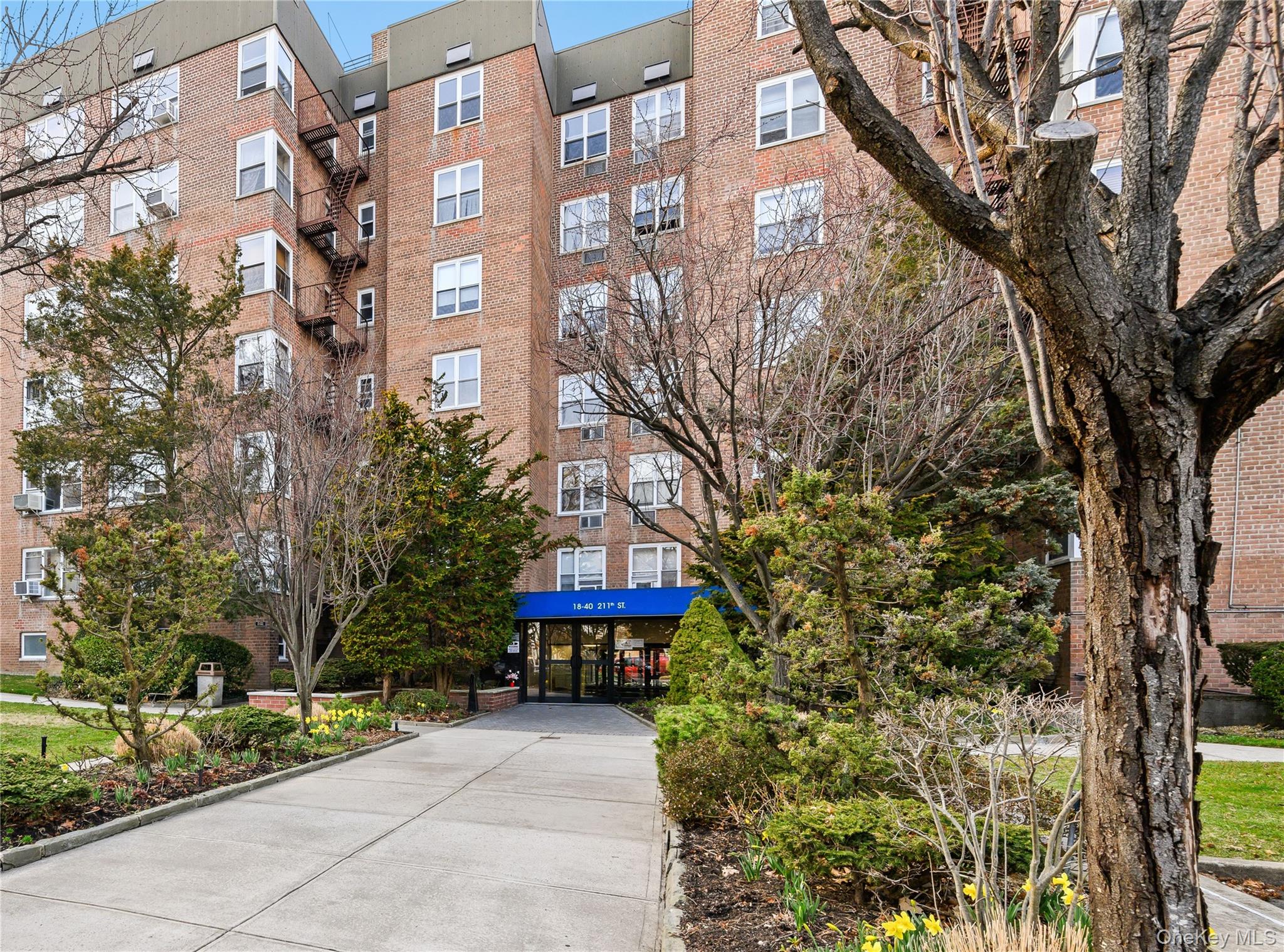 18-40 211th Street, Unit 4E Queens, NY 11360 - Photo 2 of 12 a view of a building with a tree