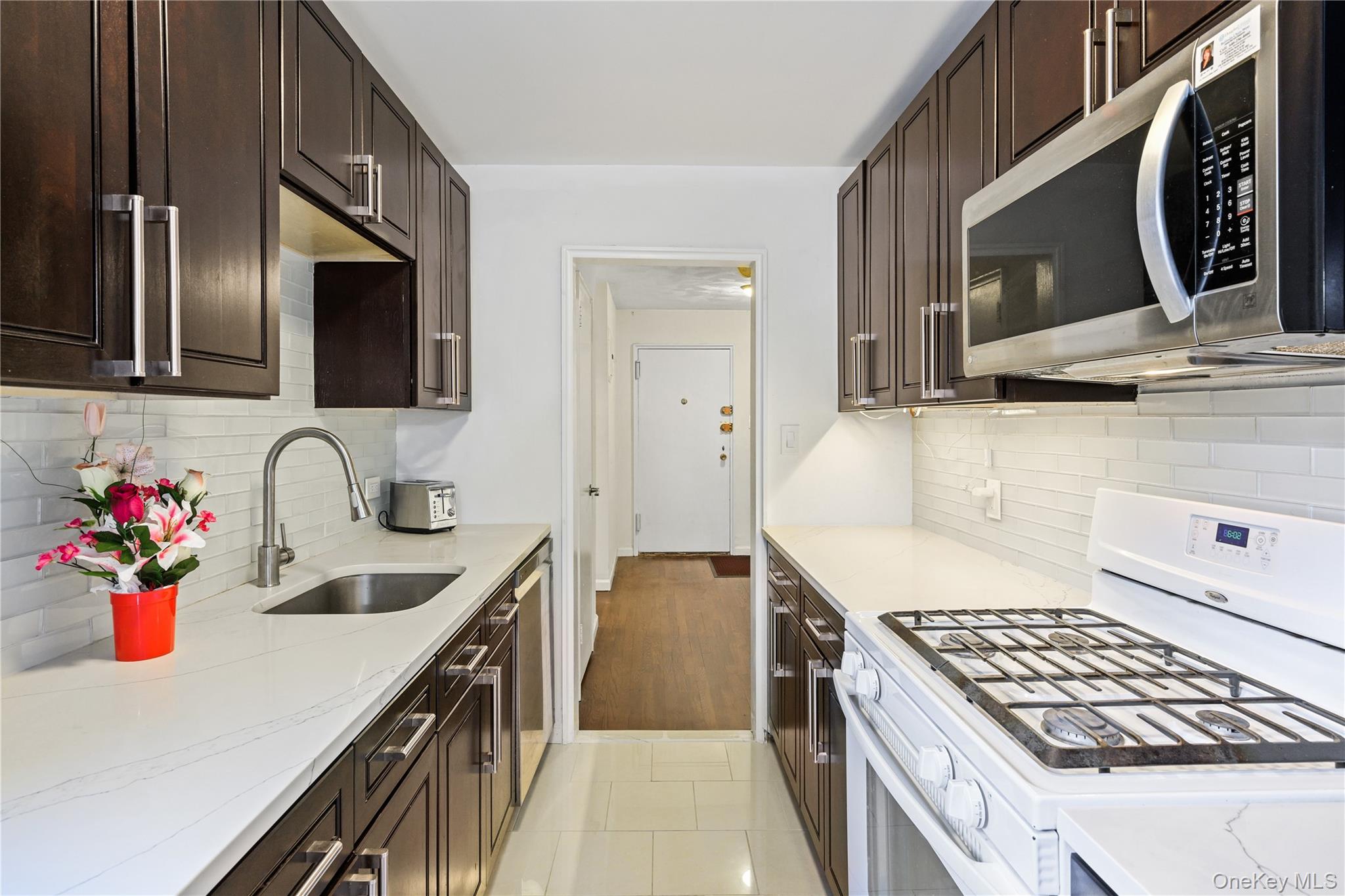 18-40 211th Street, Unit 4E Queens, NY 11360 - Photo 4 of 12 a kitchen with stainless steel appliances granite countertop a sink and a stove