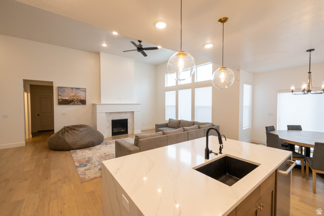 293 North Pheasant Drive Mapleton, UT 84664 - Photo 19 of 20 Kitchen with open floor plan, a center island with sink, light wood finished floors, and light stone counters