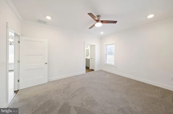 en empty room with windows and ceiling fan