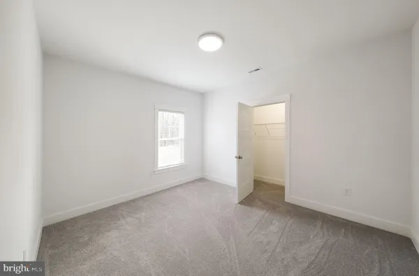 an empty room with windows and closet