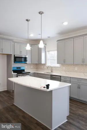 a kitchen with stainless steel appliances granite countertop a sink a stove a microwave a center island and cabinets