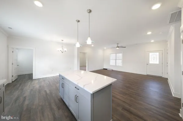 a open kitchen with a sink and dishwasher with wooden floor