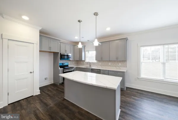 a large kitchen with stainless steel appliances kitchen island granite countertop a sink a refrigerator and a stove