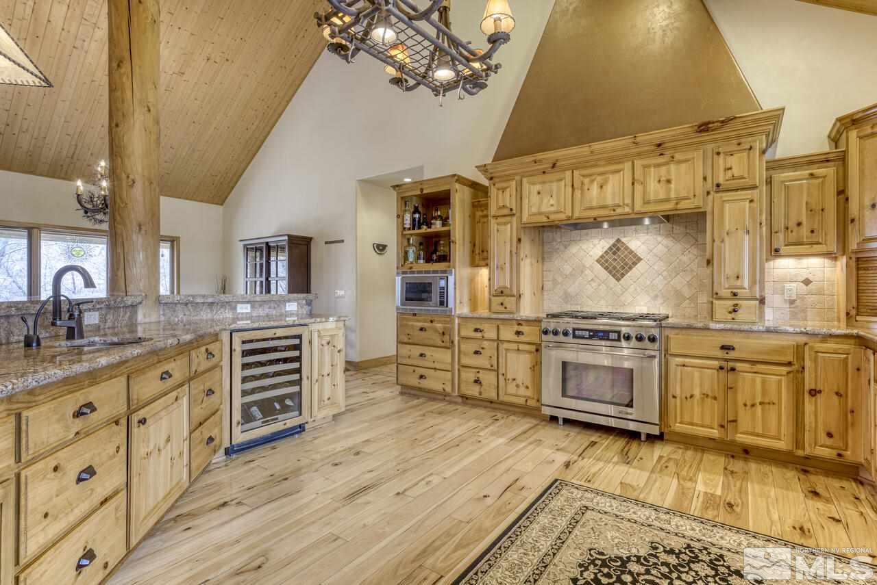 40 Grannie Lane Wellington, NV 89444 - Photo 12 of 40 a large kitchen with stainless steel appliances a stove a sink dishwasher and a oven with white cabinets