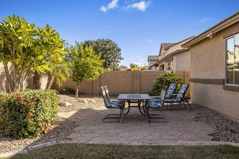 a view of a backyard with table and chairs and potted plants