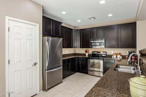 a kitchen with stainless steel appliances granite countertop a refrigerator stove top oven and sink