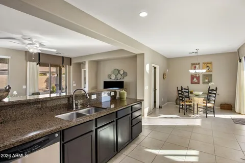 a kitchen with granite countertop a sink and chairs