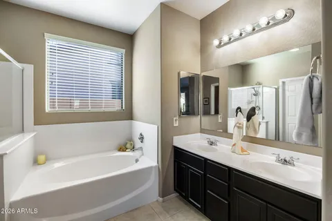 a bathroom with a tub double sink and a mirror