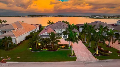 an aerial view of a house with a garden and lake view