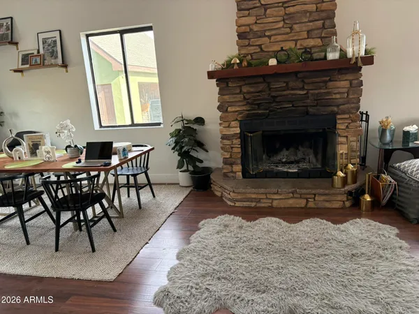 a living room with furniture a fireplace a rug and windows