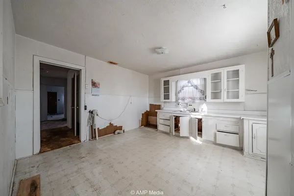 a room with kitchen island white cabinets and stainless steel appliances