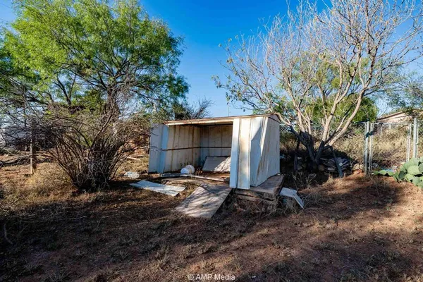 a backyard of a house with barbeque oven table and chairs