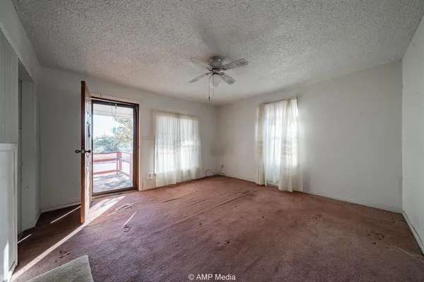 a view of a livingroom with a chandelier fan and windows
