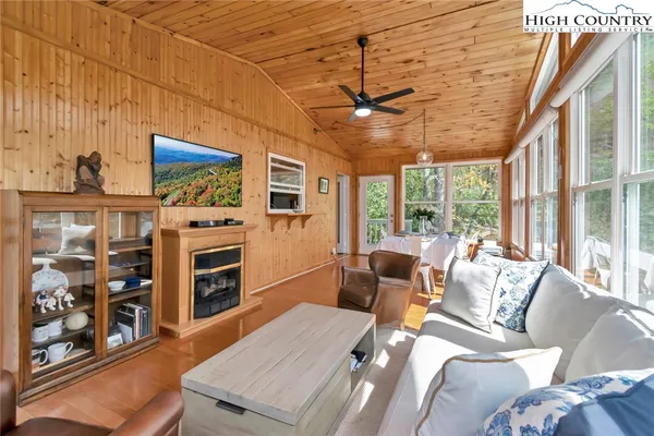 a living room with furniture a flat screen tv and a floor to ceiling window