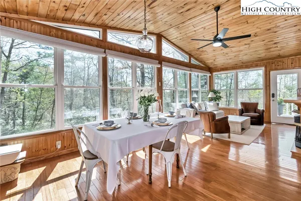 a view of a dining room with furniture large windows and wooden floor