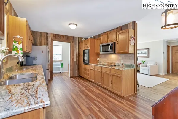 a kitchen with stainless steel appliances granite countertop a stove a sink and a refrigerator