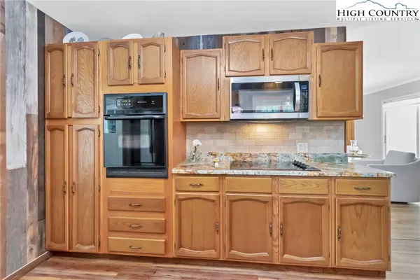 a kitchen with granite countertop a refrigerator stove and microwave