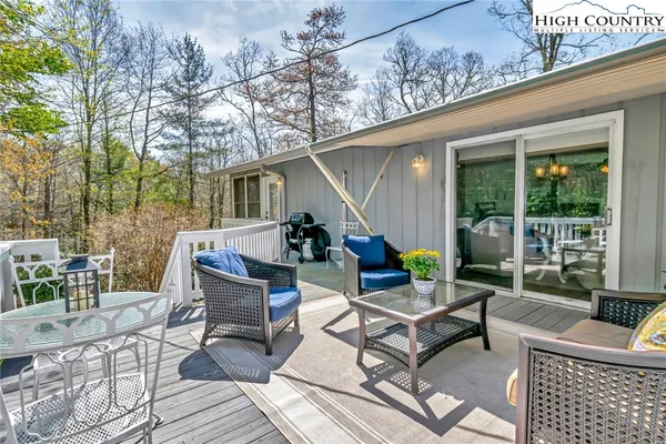 a view of a patio with a dining table and chairs with wooden floor and fence