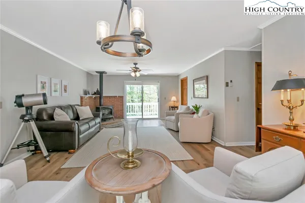 a living room with furniture or chandelier and a wooden floor