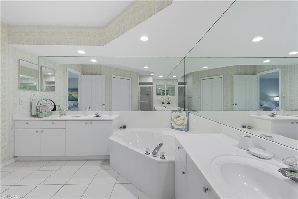 3605 Corinthian Way Naples, FL 34105 - Photo 13 of 34 a bathroom with a tub sink and mirror