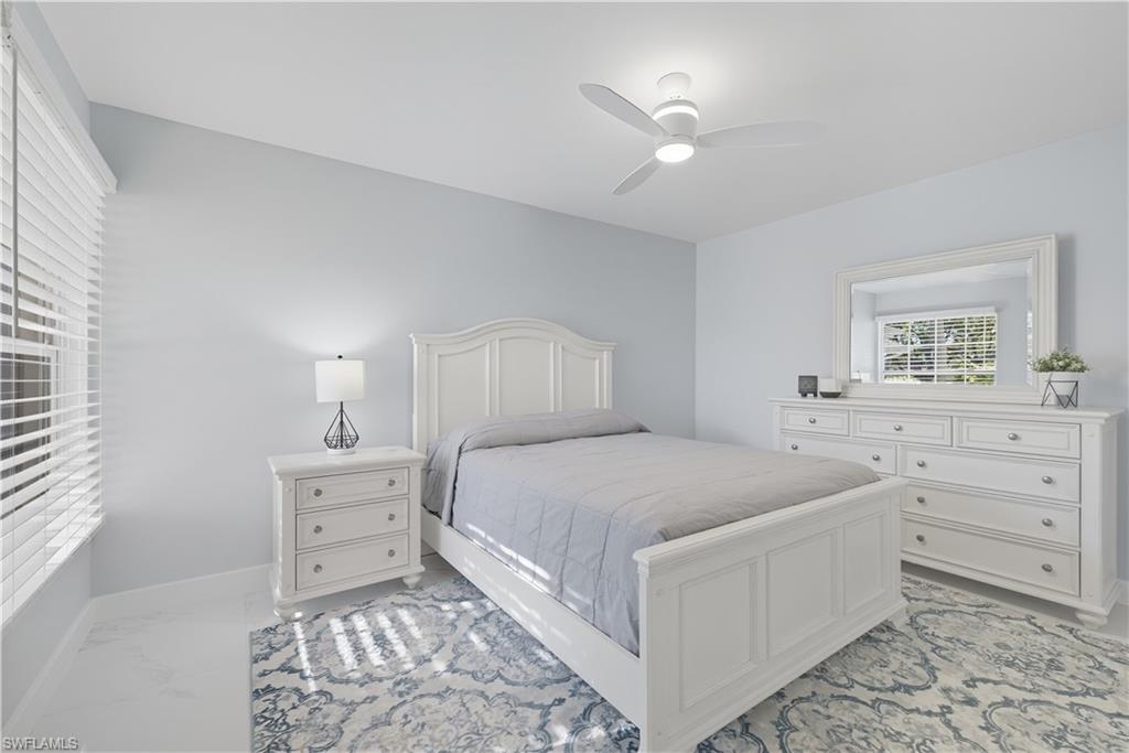 3605 Corinthian Way Naples, FL 34105 - Photo 17 of 34 a bedroom with a bed and a lamp on dresser