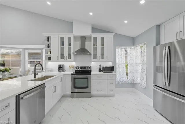 a kitchen with stainless steel appliances granite countertop a refrigerator sink and stove