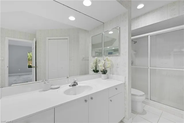 a bathroom with a double vanity sink toilet and shower