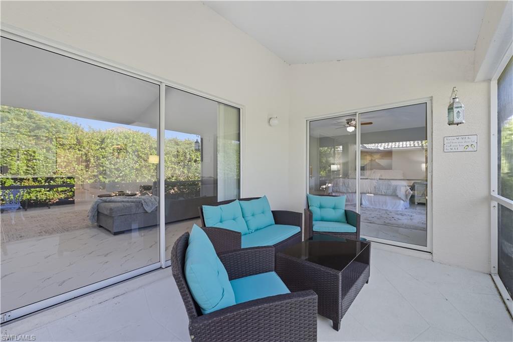 3605 Corinthian Way Naples, FL 34105 - Photo 22 of 34 a living room with furniture and a floor to ceiling window