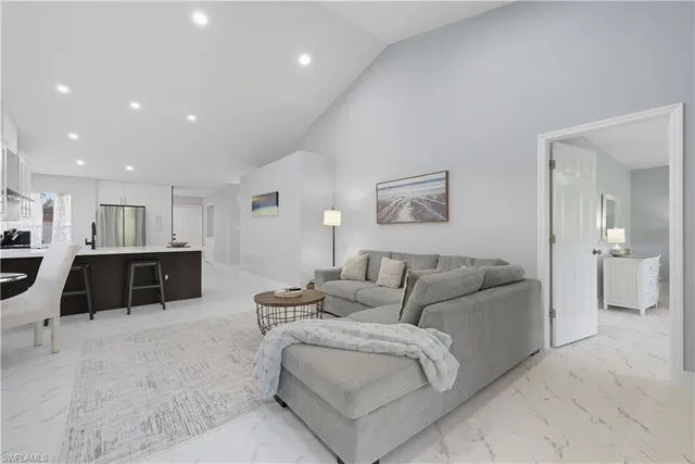 a living room with furniture and a view of kitchen