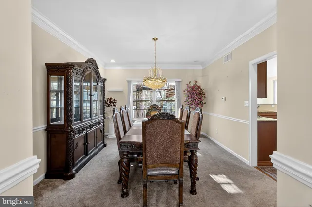 a kitchen with stainless steel appliances granite countertop a stove top oven a sink a refrigerator and white cabinets with wooden floor