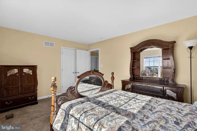 a living room with couches and kitchen view with wooden floor