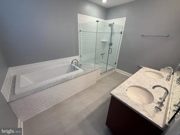 a bathroom with a granite countertop sink a mirror and shower